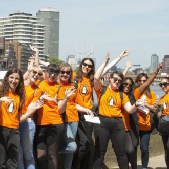 Penguin Random House employees celebrate in orange penguin tshirts