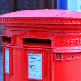 Close-up of a red postbox on a street