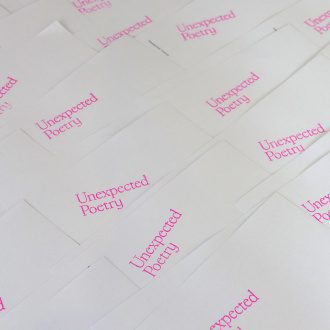 Bright white book covers are laid out in a large pile with 'Unexpected Poetry' stamped in hot pink on top
