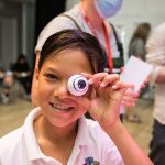 A picture of a young person holding a bobbly eye
