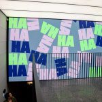 Ha Ha Hackney appears in huge, colourful, energetic letters across a wall to ceiling digital screen