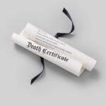 A rolled parchment tied with a black ribbon which reads death certificate