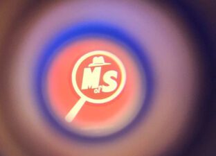 The Ministry of Stories logo has been adapted to appear in a magnifying glass, more like a spy logo.